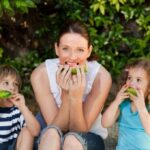 Mom and two children eating watermelon