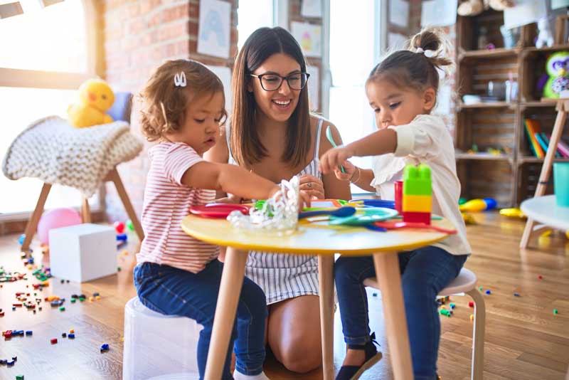 image of woman and two kids doing crafts at a table